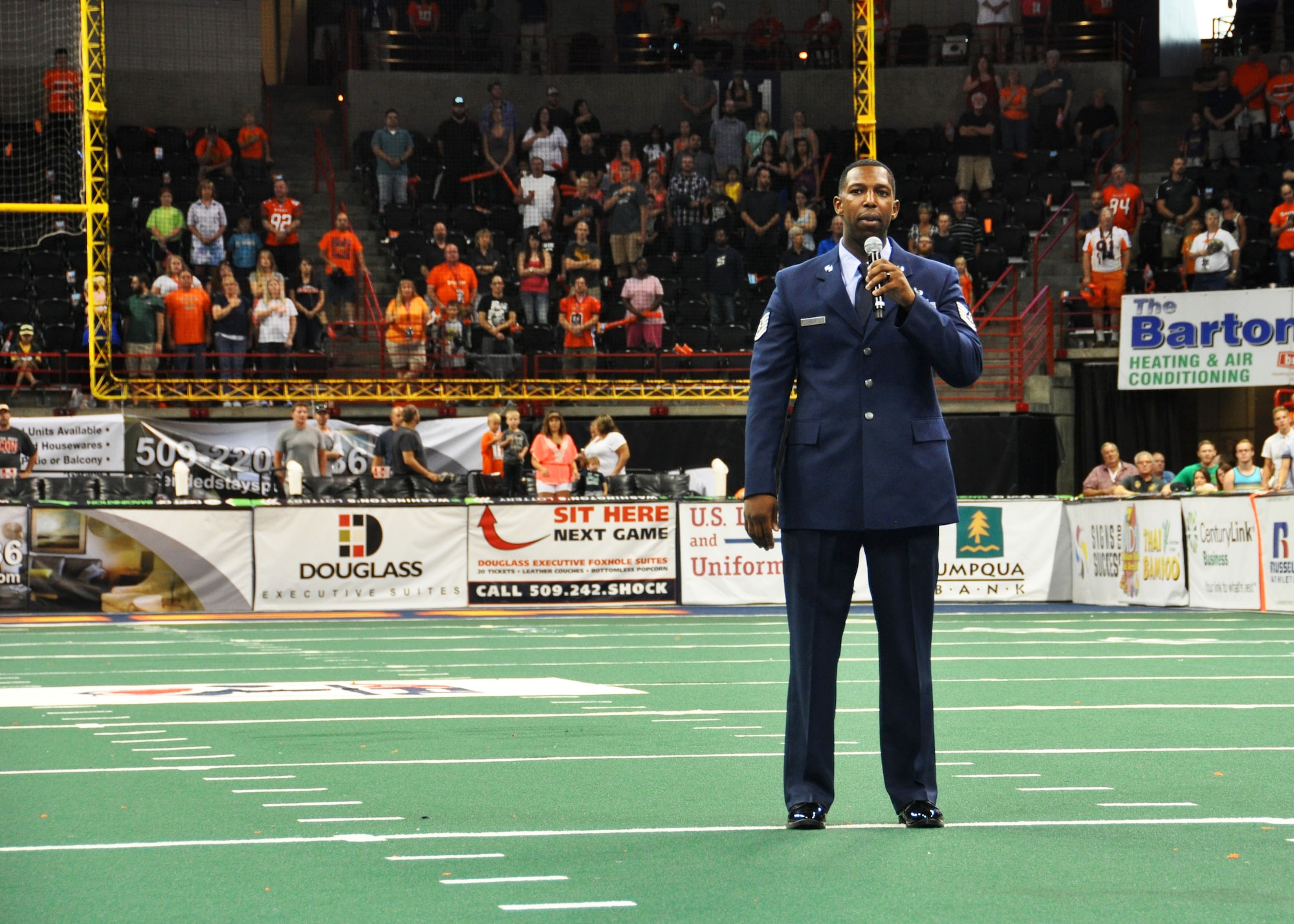 Tech. Sgt. Lloyd Kelly, 92nd Communications Squadron resource advisor, sings “God Bless America” at a Spokane Shock football game July 17, 2015, at the Spokane Veterans Memorial Arena in Spokane, Wash.  The Spokane Shock football team beat the Arizona Rattlers 52-45. (U.S. Air Force photo/2nd Lt. Shelley Gregory)