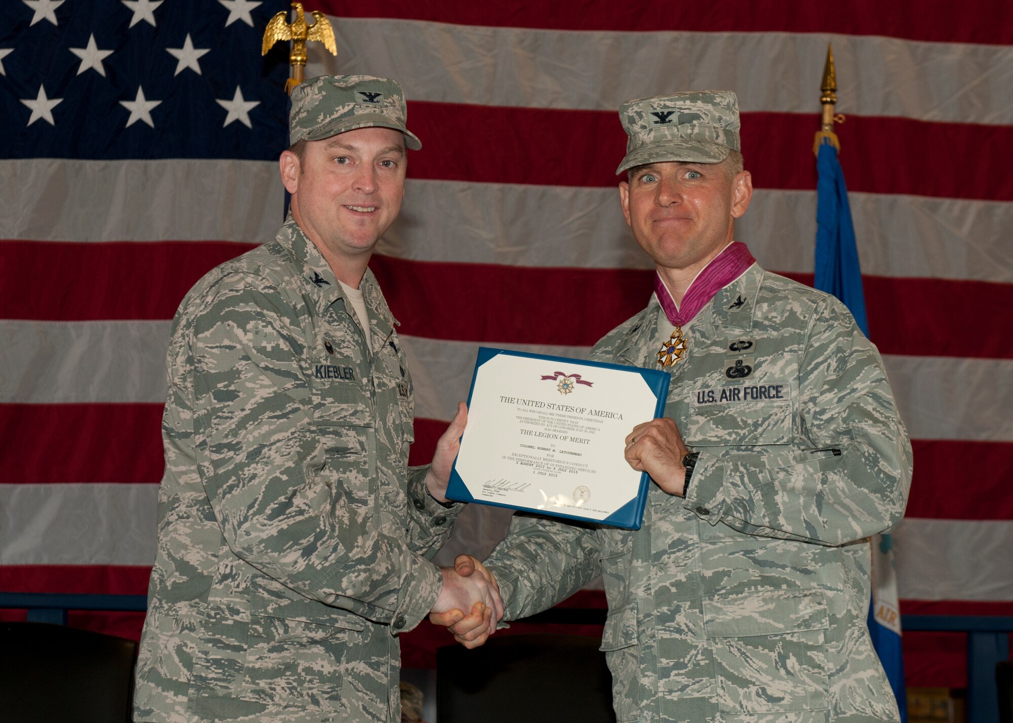 Colonel Robert Kiebler, the 49th Wing commander, presents Col. Robert Letourneau, the outgoing 49th Materiel Maintenance Group commander, with the Legion of Merit medal here on July 1 for his outstanding service with the 49th MMG at Holloman Air Force Base, N.M. The 49th MMG is the Air Force’s only Basic Expeditionary Airfield Resources base, also known as BEAR base, which can supply responsive expeditionary airfield resources and expertise to support deployed military members as well as humanitarian efforts. (U.S. Air Force photo by 49th Wing Public Affairs Office)