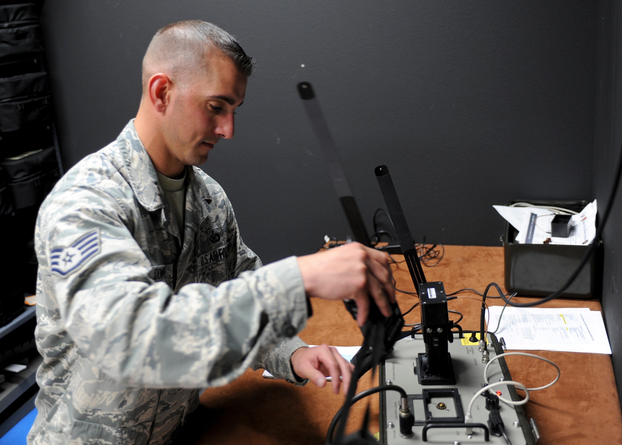 Staff Sgt. Justin McEldowney, 28th Operations Support Squadron aircrew flight equipment technician, places a Combat Survival Evader Locator radio into a radio set adapter at Ellsworth Air Force Base, S.D., June 25, 2015. The adapter, when hooked up to a computer, allows information and data to be programmed into the CSEL radios and later transmitted to aircrews flying within areas of responsibility. (U.S. Air Force photo by Senior Airman Anania Tekurio/Released) 