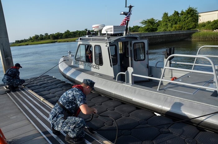 (Left) Aviation Boatswain’s Mate Fuels Curtis Clausen and Machinist Mate 2nd Class Kevin Labencki, from the 628th Logistics Readiness Squadron Port Operations, dock a Harbor Security Boat, July 21, 2015 at Joint Base Charleston – Weapons Station, S.C. The 628th LRS Port Operations received two new 27-foot Harbor Security Boats to replace older watercraft. These HSBs are highly maneuverable, welded aluminum boats powered by 150-horse powered outboard engines. The 628th LRS currently has six boats in their inventory. (U.S. Air Force photo/Staff Sgt. AJ Hyatt)
