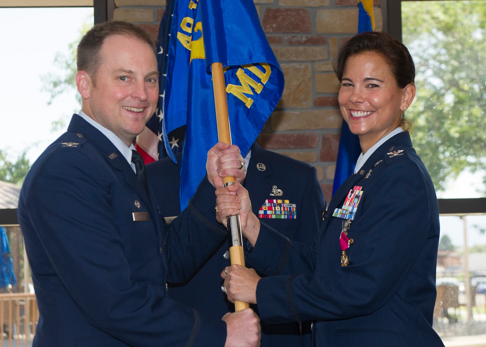Colonel Robert Kiebler, the 49th Wing commander, receives the 49th Medical Group guidon from Col. Leslie Knight, the 49th MDG outgoing commander, as part of the 49th MDG change of command ceremony at Holloman Air Force Base, N.M on July 21. Kiebler was the presiding officer over the ceremony in which Knight relinquished command of the 49th MDG to Col. Paul Willingham. (U.S. Air Force photo by Airman 1st Class Emily A. Kenney)