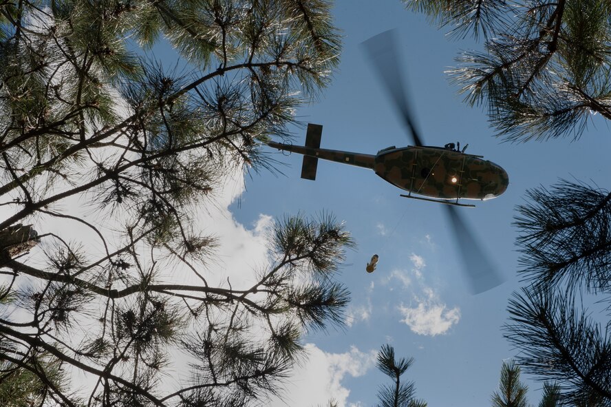 A UH-N1 Helicopter circles trees during a search and rescue training mission near Garrison, N.D., July 20, 2015. The crew practiced SAR operations in preparation for the upcoming Air Force Global Strike Command’s Global Strike Challenge. (U.S. Air Force photo/Senior Airman Stephanie Morris)