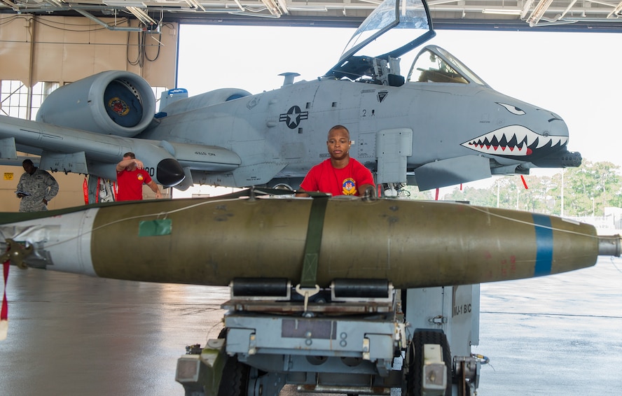 U.S. Air Force Senior Airman Keelend Smith, 75th Aircraft Maintenance Unit weapons load crew member, moves a bomb during the load crew of the quarter competition July 17, 2015, at Moody Air Force Base, Ga. The 74th and 75th AMUs faced off to determine the best load crew. (U.S. Air Force photo by Airman 1st Class Ceaira Tinsley/Released)