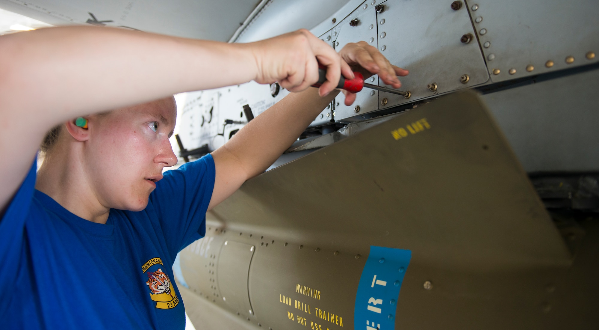 U.S. Air Force Senior Airman Caroline Held, 74th Aircraft Maintenance Unit weapons load crew member, tightens screws on a panel of the A-10C Thunderbolt II during the load crew of the quarter competition July 17, 2015, at Moody Air Force Base, Ga. Held and her team competed against the 75th AMU for the trophy and bragging rights for the quarter. (U.S. Air Force photo by Airman 1st Class Ceaira Tinsley/Released)