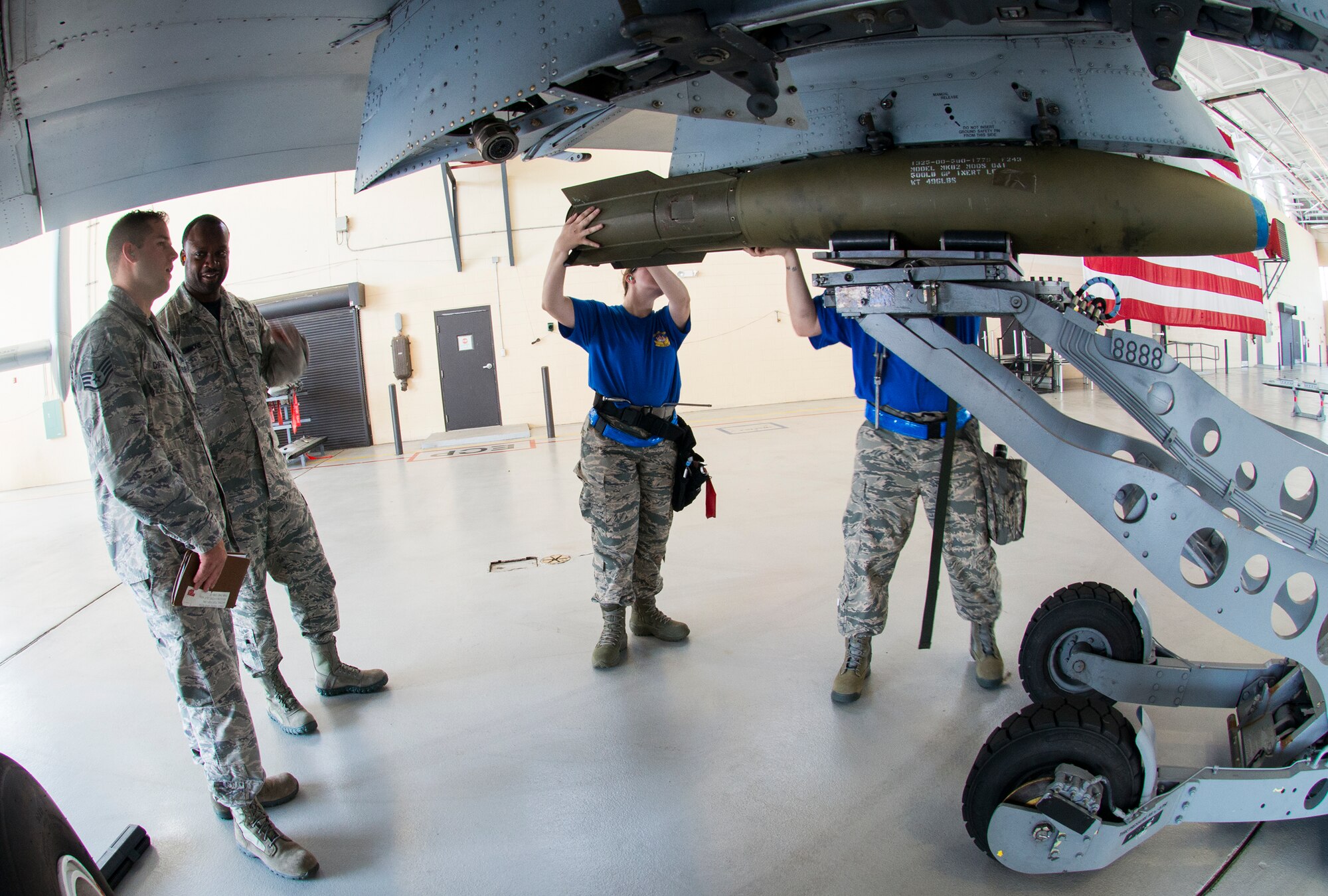 Weapons standardization evaluators from the 23d Maintenance Group discuss the techniques used by the 74th Aircraft Maintenance Unit’s weapons load team during the load crew of the quarter competition July 17, 2015, at Moody Air Force Base, Ga. Competitors were judged on dress and appearance, a knowledge exam and loading various munitions the quickest and most efficiently. (U.S. Air Force photo by Airman 1st Class Ceaira Tinsley/Released)