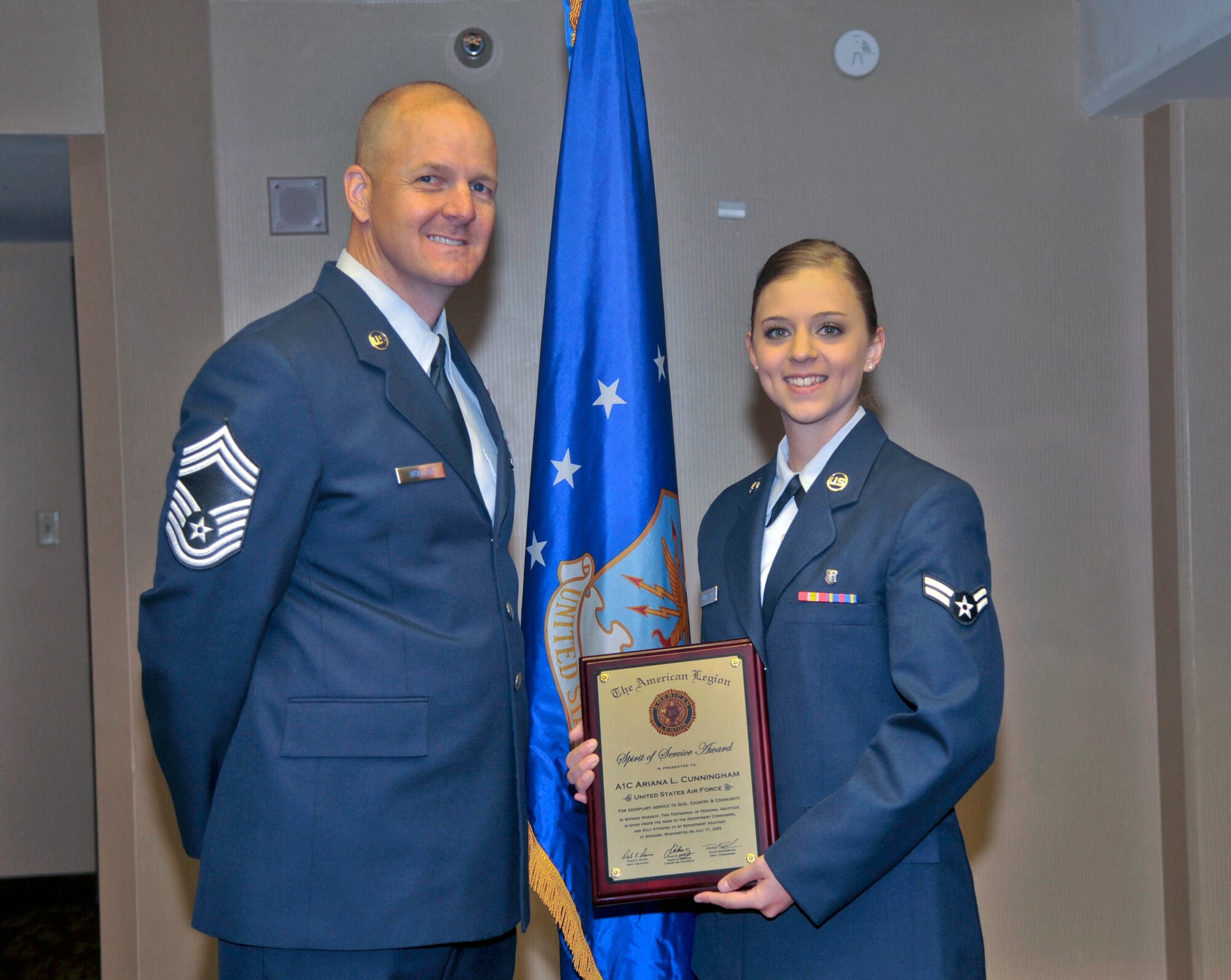 Airman 1st Class Ariana Cunningham, 92nd Medical Group dental assistant, poses with Chief Master Sgt. Robert Mueller, 92nd Mission Support Group superintendent, after the American Legion’s Spirit of Service award presentation July 17, 2015, at the Red Lion Hotel in Spokane, Wash. Cunningham received the SOS award for volunteering more than 300 hours in her community. The SOS award is awarded to enlisted personnel below the rank of E-6 who not only excel in their daily duty performance, but also devote time serving in their communities. (U.S. Air Force photo/Airman 1st Class Taylor Bourgeous)