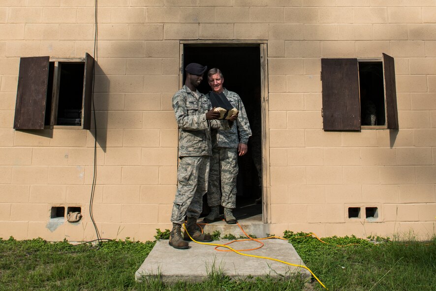 U.S. Air Force Senior Airman Jordan Gourdine, left, 820th Combat Operations Squadron technologies assistant, briefs the capabilities of the RQ-11B Raven to U.S. Air Force Gen. Hawk Carlisle, commander Air Combat Command, July 16, 2015, at Moody Air Force Base, Ga. The RQ-11B is an unmanned aircraft system used by the 820th Base Defense Group to gather real-time situational awareness and target information. (U.S. Air Force photo by Senior Airman Ryan Callaghan/Released)