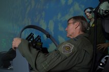 U.S. Air Force Gen. Hawk Carlisle, commander Air Combat Command, pilots the A-29 Super Tucano simulator while a pilot from the 81st Fighter Squadron, provides instructions during his visit July 15, 2015, at Moody Air Force Base, Ga. Carlisle toured various units of the 23d Wing and 93d Air Ground Operations Wing during his two-day visit to Moody. (U.S. Air Force photo by Staff Sgt. Eric Summers Jr./Released)