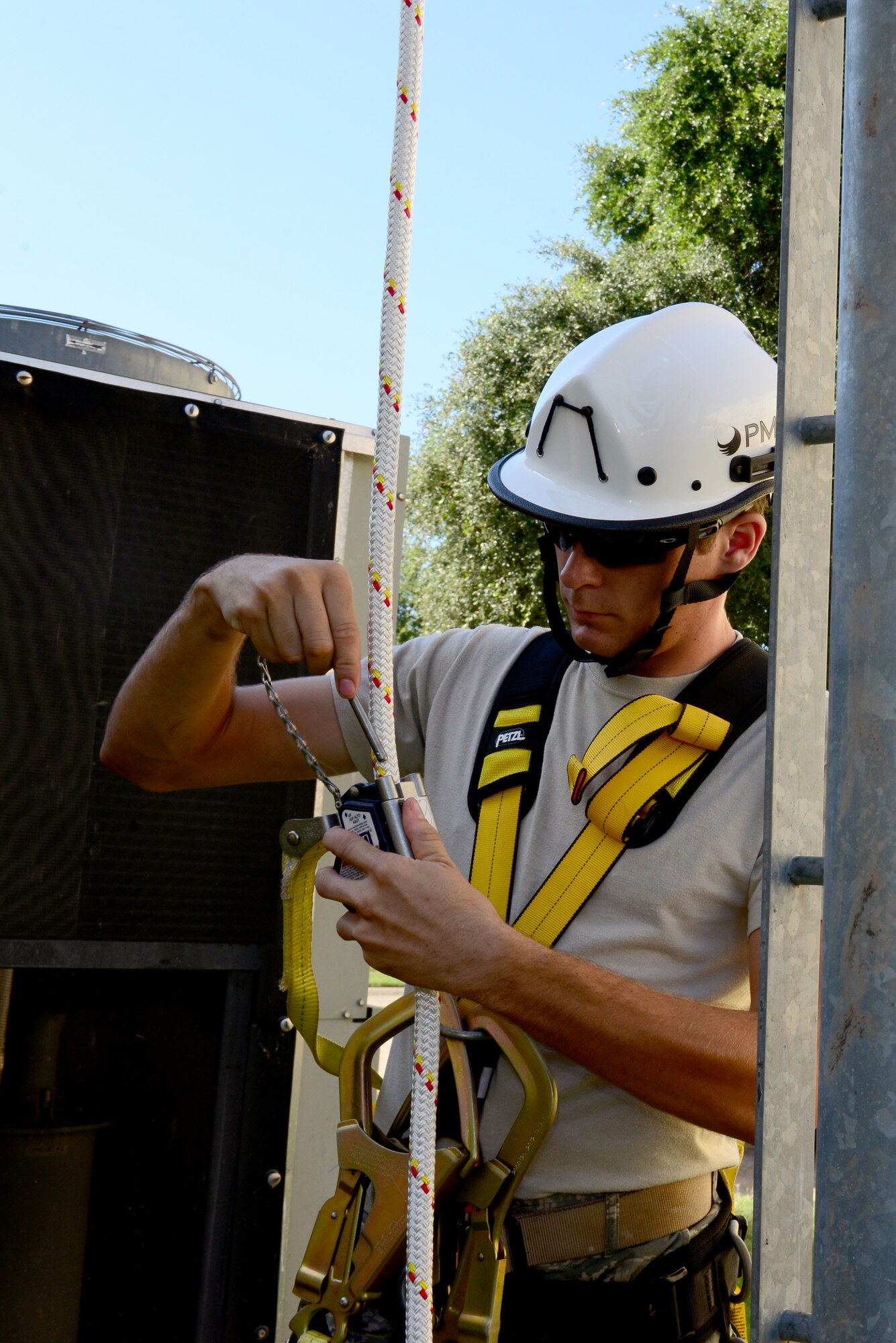 Airman 1st Class Chris Bailey, 2nd Communication Squadron cable and antenna systems Maintainer, prepares his safety restraint before climbing a communication tower on Barksdale Air Force Base, La., July 15, 2015. Cable and Antenna Systems Airmen must ensure everything is secure before they begin climbing. (U.S. Air Force Photo/Airman 1st Class Luke Hill)