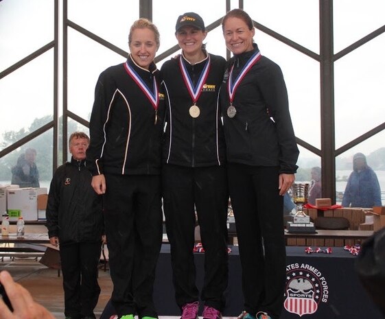 Major Jamie Turner proudly stands on the winners’ podium with 2nd Lt. Samone Franzese and 2nd Lt. Jessica Clay at the Armed Forces Triathlon Championship race in Hammond, Indiana, June 7, 2015. Turner (right) continued her world-class triathlete success as the second female to cross the finish line and automatically qualified as one of six athletes to compete on the women’s team at the Military World Games in Mungyeong, South Korea, Oct. 2-11, 2015. Turner is a C-17 pilot with the 317th Airlift Squadron. Franzese, a medical student with the U.S. Army, finished first, and Clay, from Camp Casey, Korea finished third in the competition. (Courtesy photo)