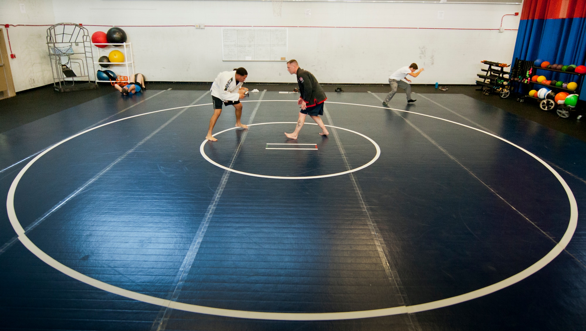Senior Airman Victor Alcon (left) and Staff Sgt. Staff Sgt. Jeffrey Zastrow, 96th Aerospace Medicine Squadron, practice wrestling techniques on a new multipurpose mat at the Eglin Fitness Center July 9. The center recently installed a multipurpose mat to expand fitness program options to its patrons. (U.S. Air Force Photo/Samuel King Jr.)
