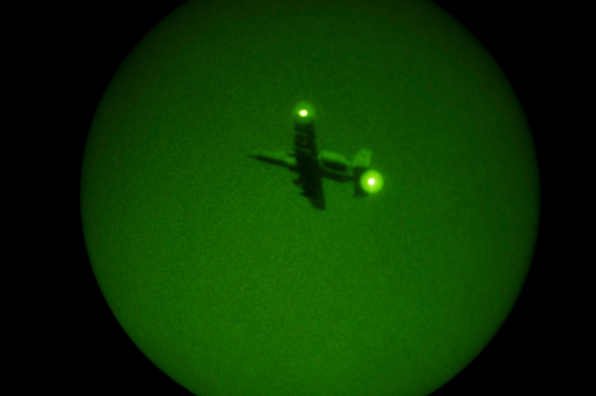 A 354th Expeditionary Fighter Squadron A-10C Thunderbolt II aircraft flies overhead at night during an austere landing training exercise at Nowe Miasto, Poland, July 20, 2015. During night hours, pilots will use night vision goggles to land on an unimproved surface when no light is available. (U.S. Air Force photo by Airman 1st Class Luke Kitterman/Released)