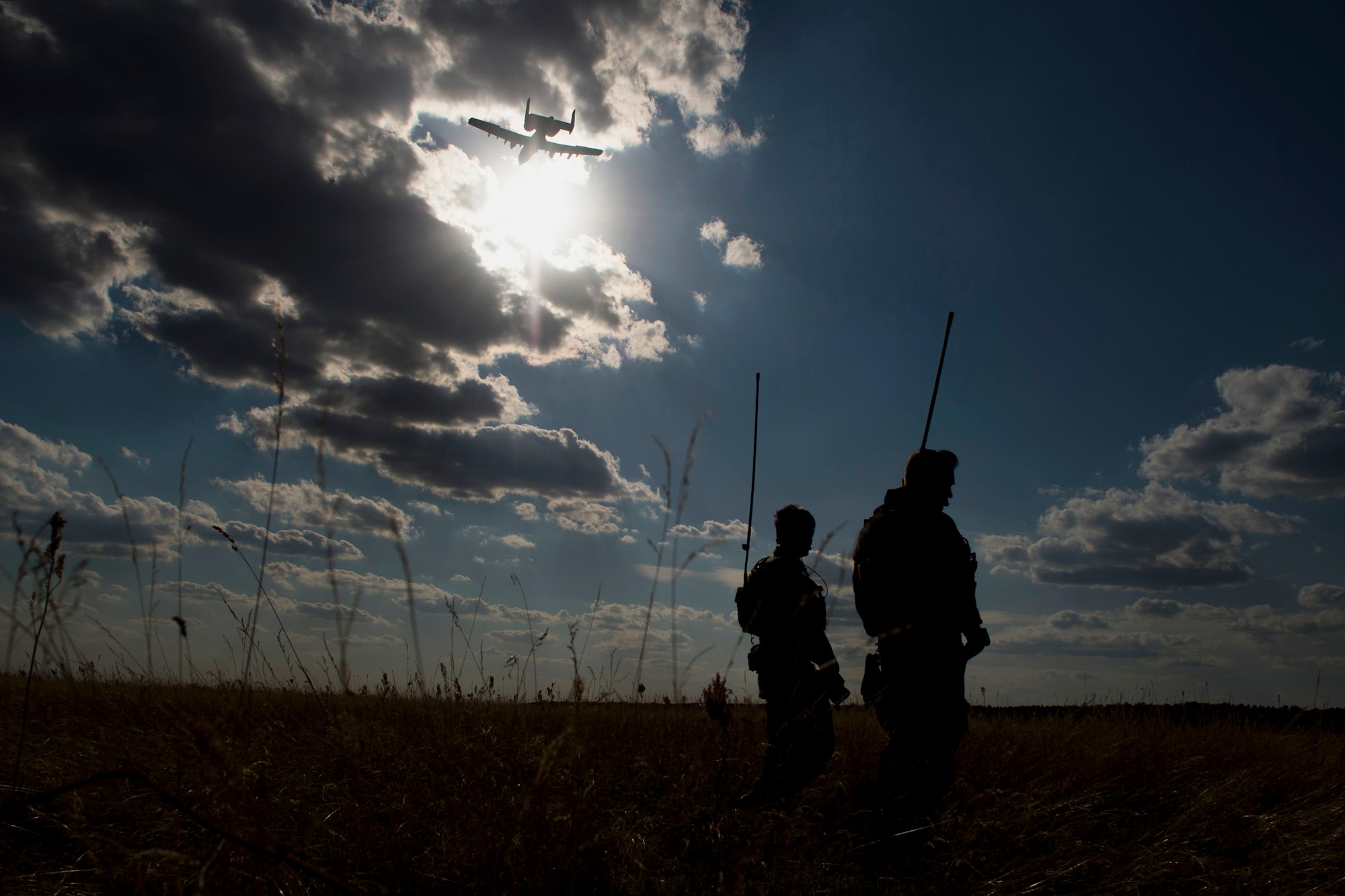 Two 321st Special Tactics Squadron combat controllers watch as a 354th Expeditionary Fighter Squadron A-10C Thunderbolt II aircraft flies overhead during an austere landing training exercise at Nowe Miasto, Poland, July 20, 2015. The 321st STS provided ground air control for the A-10 pilots. (U.S. Air Force photo by Airman 1st Class Luke Kitterman/Released)