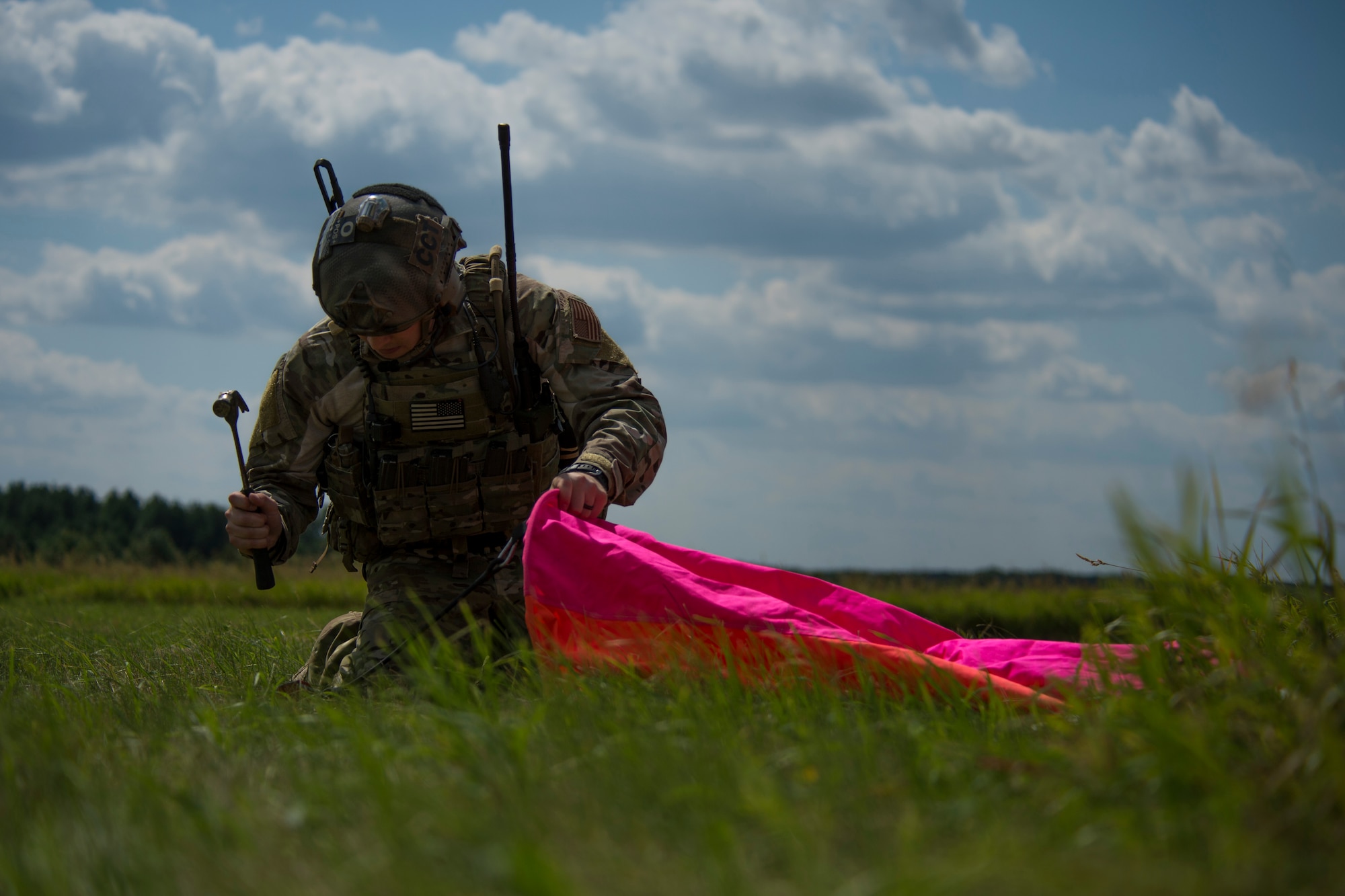 A 321st Special Tactics Squadron combat controller hammers a distance marker into place before the start of an austere landing training exercise at Nowe Miasto, Poland, July 20, 2015. The colorful markers are used as a reference point to aid pilots when landing on unimproved surfaces. (U.S. Air Force photo by Airman 1st Class Luke Kitterman/Released)