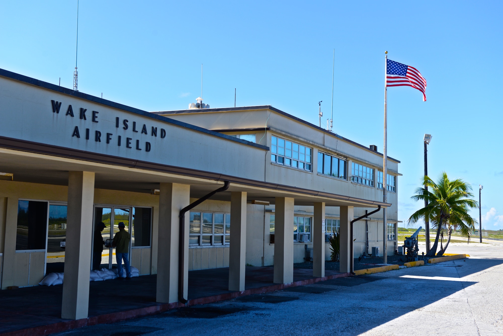 An contractor assigned to Wake Island Airfield opens the passenger terminal building July 20, 2015, after a typhoon hit the small atoll and forced the entire staff to evacuate the island a few days earlier. A team with the 36th Contingency Response Group at Andersen Air Force Base, Guam, deployed to the atoll to assist in airfield storm recovery efforts. (U.S. Air Force photo by Senior Airman Alexander W. Riedel/Released)