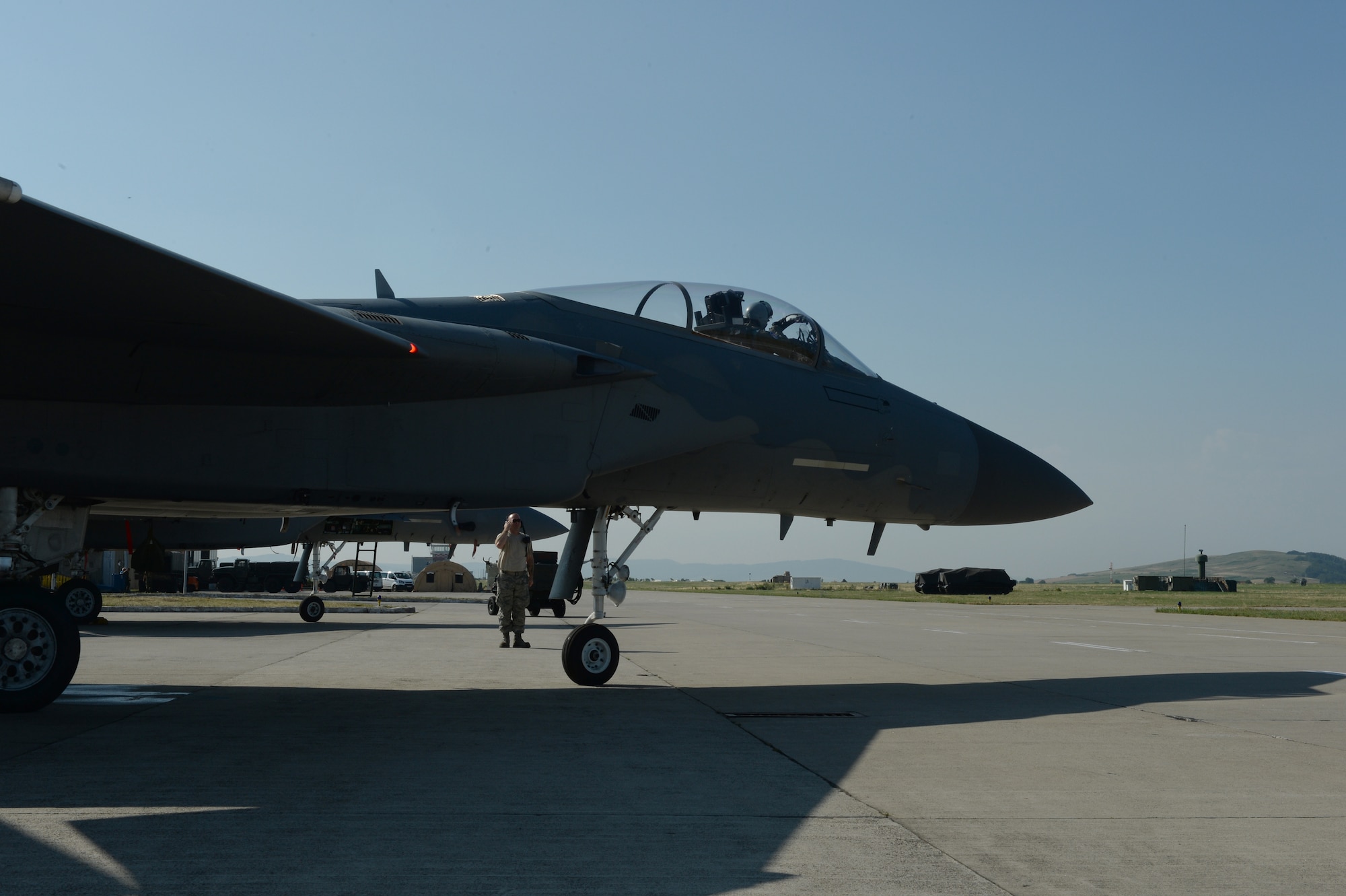 A U.S. Air National Guard crew chief from the 123rd Expeditionary Fighter Squadron salutes the pilot of an U.S. Air Force F-15C Eagle fighter aircraft during a theater security package deployment July 21, 2015, at Campia Turzii, Romania. The aircraft deployed to Romania in support of Operation Atlantic Resolve to bolster air power capabilities while underscoring the U.S. commitment to European security and stability. (U.S. Air Force photo by Senior Airman Dylan Nuckolls/Released)