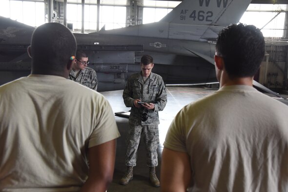 U.S. Air Force Senior Airman Robert Dickinson, 35th Maintenance Group squadron load crew member, consults his technical guide during a weapons load certification at Misawa Air Base, Japan, July 21, 2015. During Dickinson’s evaluation process, he hand-checks for any discrepancies where each armament was loaded and reviews his technical guide ensuring a perfect process. (U.S. Air Force photo by Senior Airman Patrick S. Ciccarone/Released)