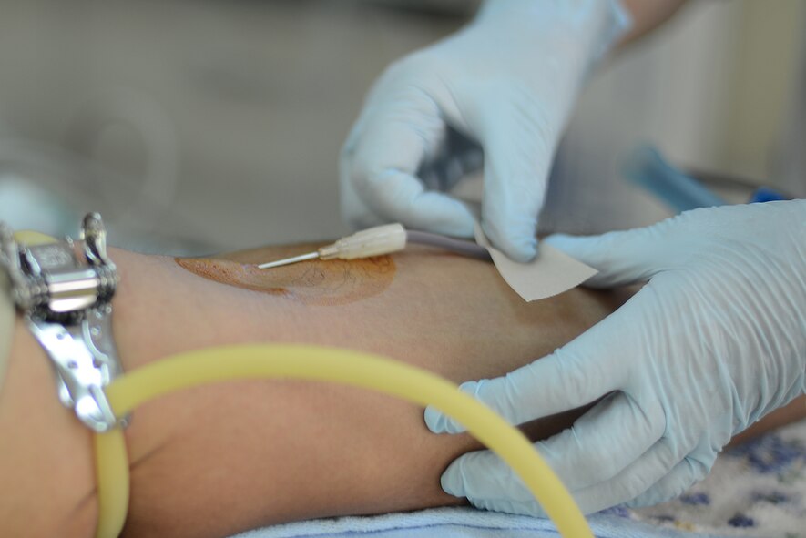 Blood is drawn from Staff Sgt. Denny Lora, 374th Communications Squadron systems control supervisor, during a Japanese Red Cross Society blood drive at Yokota Air Base, Japan, July 21, 2015. Blood donations to the JRCS save approximately 1.2 million lives every year. (U.S. Air Force photo by Airman 1st Class David C. Danford/Released)