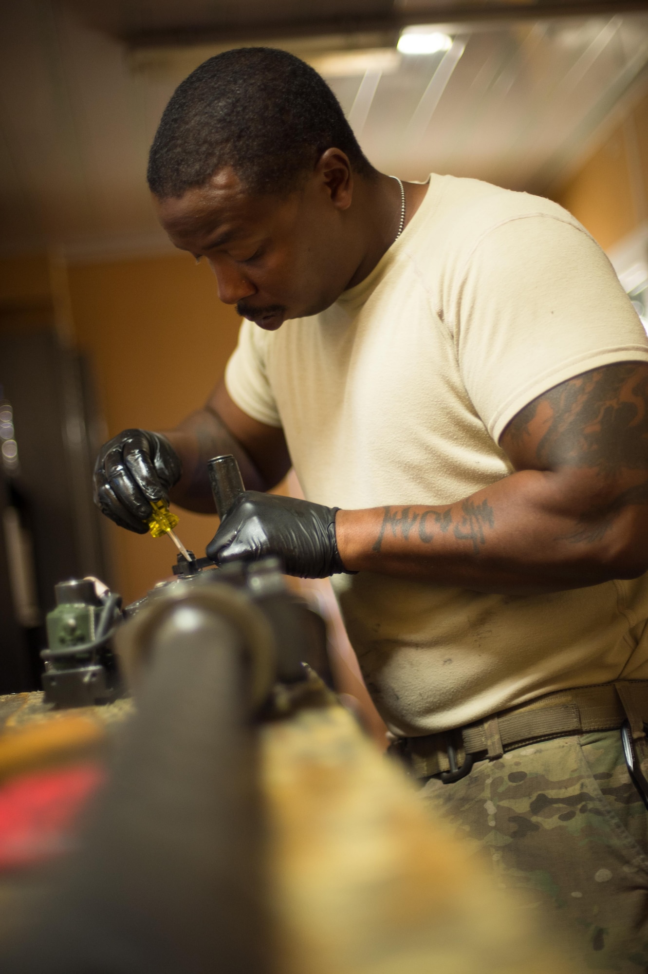 U.S. Air Force Staff Sgt. Robert Smith, 455th Expeditionary Aircraft Maintenance HH-60 Pave Hawk weapons, inspects an M2 .50 caliber machine gun at Bagram Airfield, Afghanistan, July 21, 2015. The weapon system maintainers work to keep the Pave Hawks armed so that the combat rescue mission in Afghanistan is successful. (U.S. Air Force photo by Tech. Sgt. Joseph Swafford/Released)
