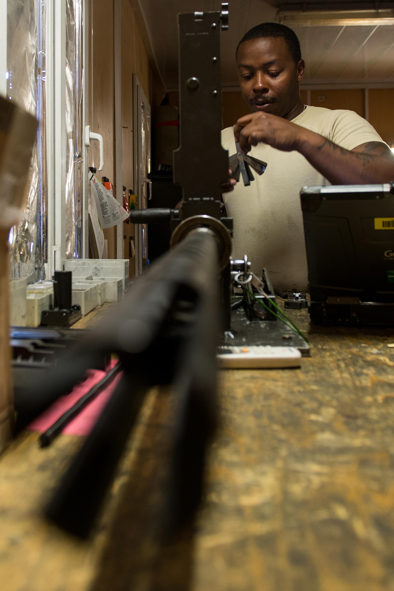 U.S. Air Force Staff Sgt. Robert Smith, 455th Expeditionary Aircraft Maintenance HH-60 Pave Hawk weapons, inspects an M2 .50 caliber machine gun at Bagram Airfield, Afghanistan, July 21, 2015. The weapon system maintainers work to keep the Pave Hawks armed so that the combat rescue mission in Afghanistan is successful. (U.S. Air Force photo by Tech. Sgt. Joseph Swafford/Released)