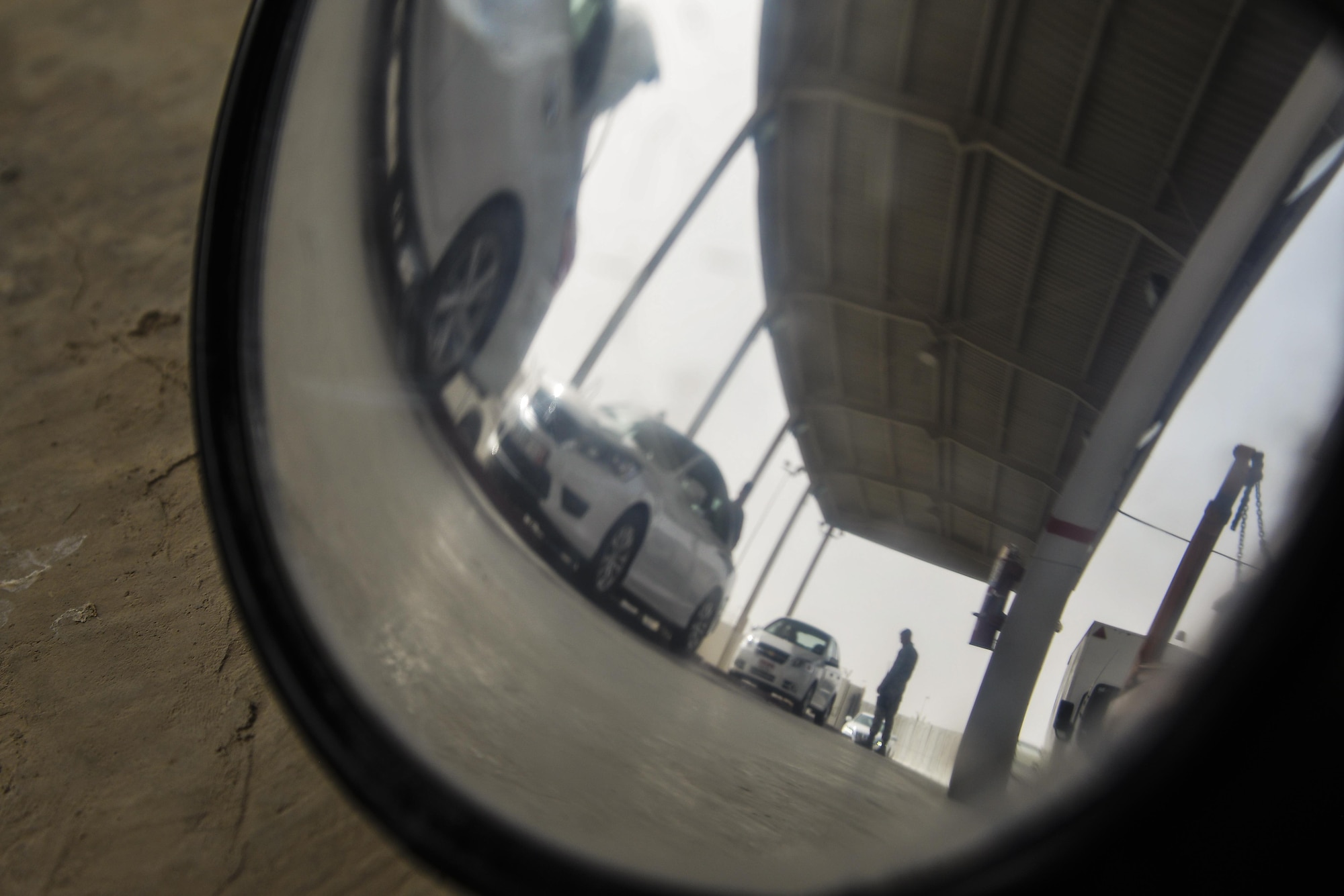 380th Expeditionary Security Forces Squadron team members search vehicles for contraband in the vehicle search area at an undisclosed location in Southwest Asia July 13, 2015. (U.S. Air Force photo/Tech. Sgt. Christopher Boitz)