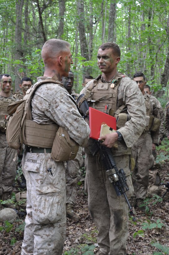 During a field exercise on July 15, 2nd Lt. Matthew George, a student at The Basic School, listens to comments from his commanding officer after receiving a Navy and Marine Corps Achievement Medal for his lifesaving actions taken on June 21.