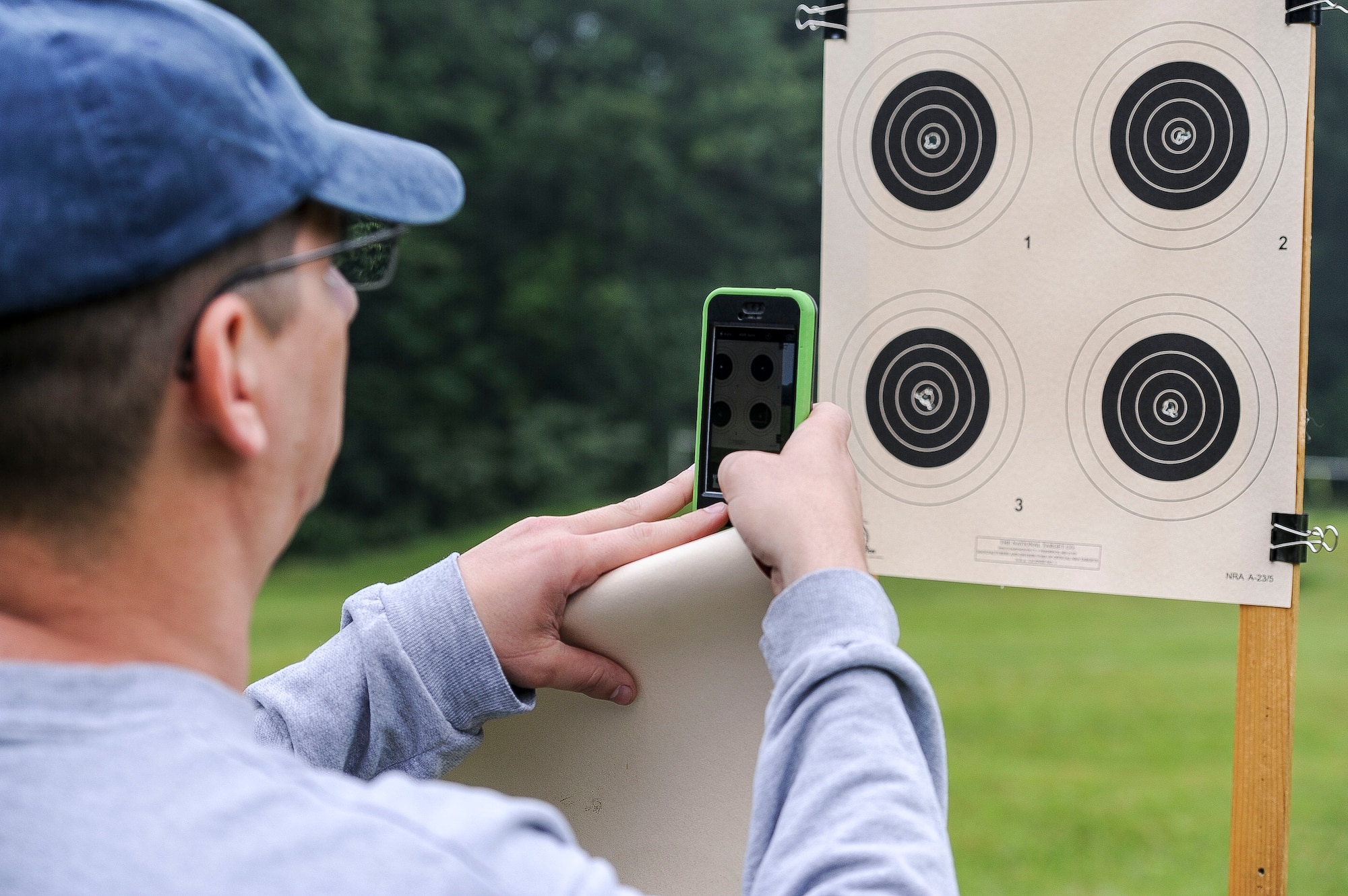 Lt. Col. Mark Gould takes a picture of his grouping as he admires his shots during a training class in New Freedom, Pa., June 26, 2015. Gould, a foreign liaison officer for the Defense Intelligence Agency’s Office of Partner Engagement at the Pentagon, has been involved in competitive shooting for the past 23 years and has been a member of the Air Force International Rifle Team for 17 years. (U.S. Air Force photo/Staff Sgt. Christopher Gross)