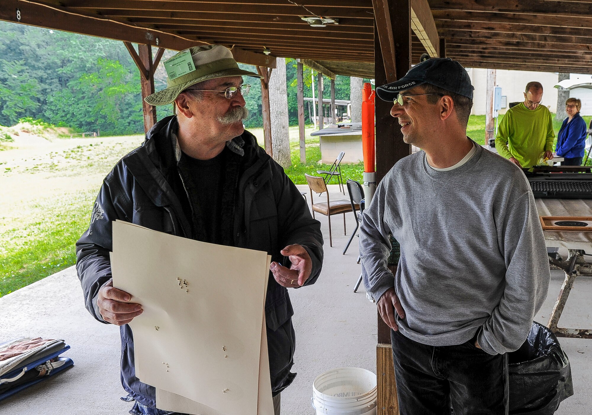 Lt. Col. Mark Gould (right) hands in his target and talks to instructor George Harris during a training class in New Freedom, Pa., June 26, 2015. Gould, a foreign liaison officer for the Defense Intelligence Agency’s Office of Partner Engagement at the Pentagon, has been involved in competitive shooting for the past 23 years and has been a member of the Air Force International Rifle Team for 17 years. Harris, a former manager of National Rifle Association rifle competitions for 26 years, instructed the two-day course. (U.S. Air Force photo/Staff Sgt. Christopher Gross)