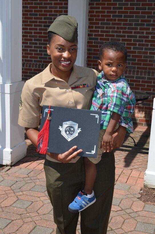 Sgt. Biannca Clarke proudly displays her graduation certificate, as she holds her younger son, O’Dell, 2. Clarke, an active duty Marine and single mother of two, earned a bachelor’s degree in psychology from Ashford University.