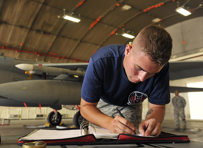 U.S. Air Force Airman 1st Class Brady Clark, 18th Aircraft Maintenance Squadron weapons load crew member, annotates his checklist during the second-quarter weapons load competition on Kadena Air Base, Japan, July 17, 2015. Weapons load competitions are conducted quarterly to keep Airmen sharp and recognize superior performers. Teams are evaluated for use of the checklist, safety and overall speed. (U.S. Air Force photo by Naoto Anazawa/Released)