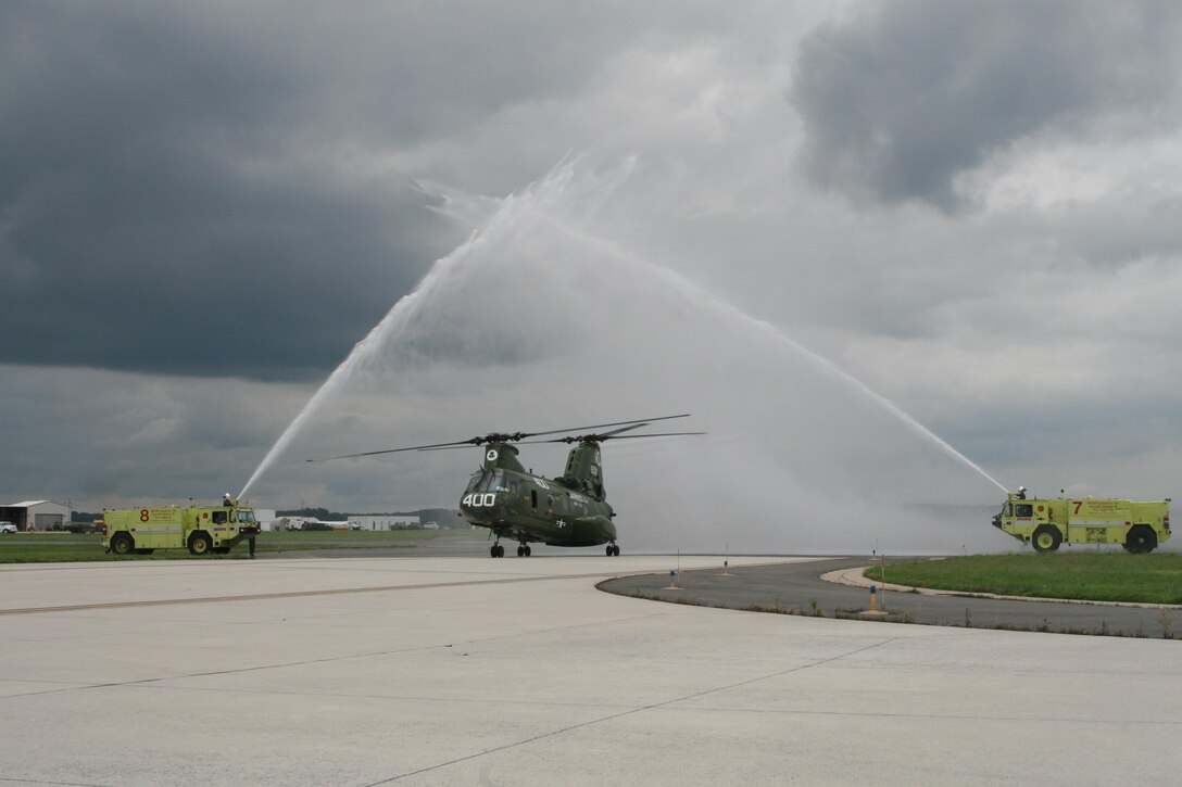 The CH-46 Phrog helicopter rolling in and celebrating its final flight before getting phased out. The Phrog was greeted with twin fire hoses, reminiscent of the arch of swords.