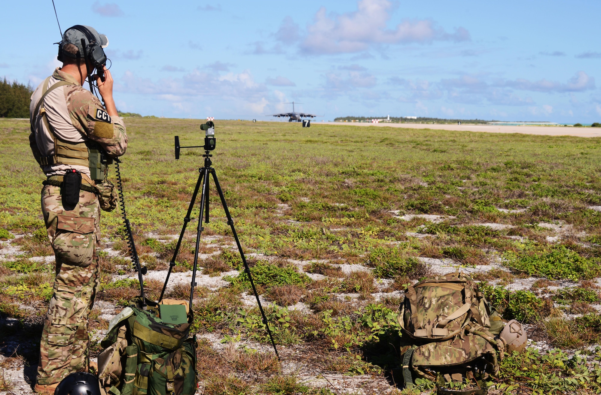 A combat controller from the 320th Special Tactics Squadron clears the first C-17 Globemaster III from Joint Base Pearl Harbor-Hickam, Hawaii, to land on Wake Island July 20, 2015 after it was hit by a typhoon.  The special tactics team was the first to arrive to the island by military freefall jump from an MC-130H Combat Talon II.  Members from the 353rd Special Operations Group worked with the 36th Contingency Response Group from Andersen Air Base, Guam, to open Wake Island air field after Typhoon Halola passed through the island. (U.S. Air Force photo by Tech. Sgt. Kristine Dreyer)