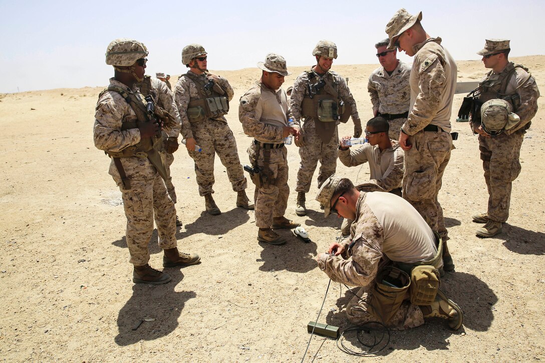 U.S. Marines observe as a team member prepares an explosive charge during a demolition range in Southwest Asia, July 17, 2015.