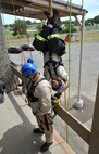 Staff Sgt. Brandin McGovern, 120th Civil Engineer Squadron, Montana Air National Guard, hangs inverted as he prepares to ‘rescue’ fellow firefighter Norman Semanik, 90th CES, F. E. Warren Air Force Base, Wyo., at the City of Great Falls Fire Training Center July 22. 2015. Rescue Technician One training teaches Air Force firefighters techniques for extracting victims from ledges and confined spaces. Instructors from Goodfellow AFB, Texas, were in Great Falls to teach the 15-day course. (U.S. Air Force photo/ John Turner)
