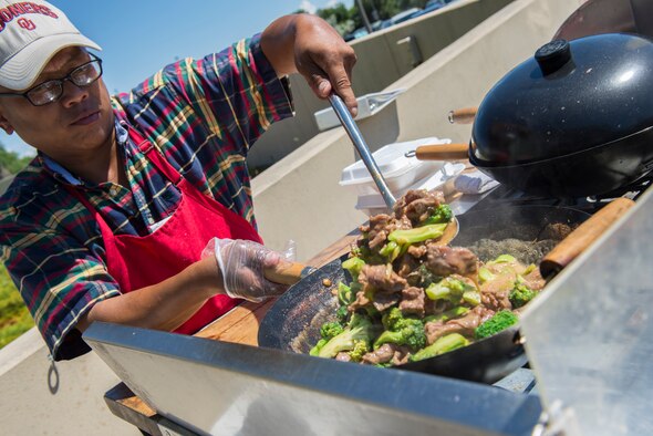 Kriangsak Blechinger cooks up a meal outside the Base Exchange at Mountain Home Air Force Base, Idaho, July, 15, 2015. Blechinger has a Thai food cart set up to serve authentic cuisine to the local community. (U.S. Air Force photo by Senior Airman Malissa Lott/RELEASED)