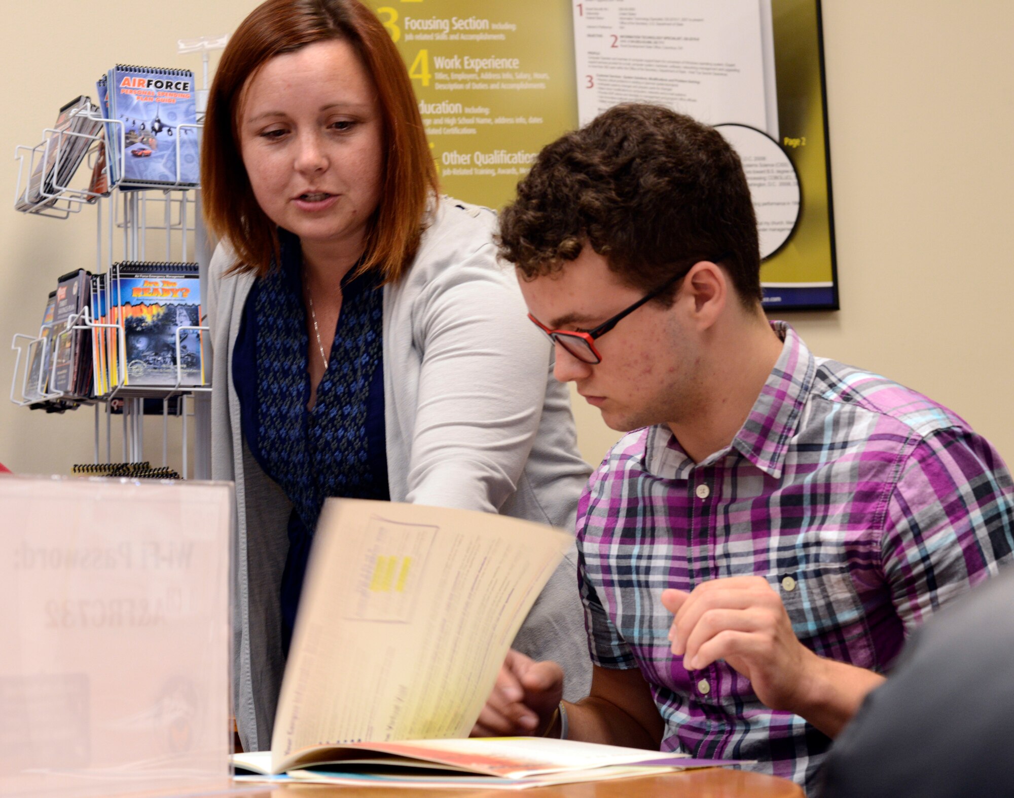 Amy L. Jensen, 22nd Force Support Squadron Airman & Family Readiness Center civilian school liaison officer, shows a brochure containing information about how to plan for colleges and a career to Nathan Kampe, a student at a local school here, during a SAT/ACT prep workshop at McConnell Air Force Base, July 22, 2015.  The workshop was organized by the 22nd Force Support Squadron.  As a civilian school liaison officer, Jensen helps newly assigned families ensure a smooth transition to new school in Wichita and the surrounding communities.   (U.S. Air Force photo by Tech. Sgt. Olufemi A. Owolabi)