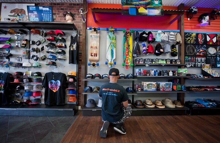 Retired Tech. Sgt. Alfredo Sibucao Jr. organizes a hat display inside his retail store in Las Vegas, June 22, 2015. Sibucao, who attended middle and high school in Las Vegas, spent a combined 13 years between Nellis and Creech Air Force Bases before retiring and opening his business in Las Vegas. (U.S. Air Force photo by Staff Sgt. Siuta B. Ika)