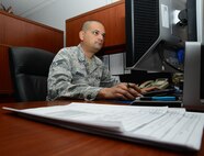 Senior Airman Brandon Bassett, 22nd Comptroller Squadron financial management technician, ensures travel days are properly accounted for, July 23, 2015, at McConnell Air Force Base, Kan. Financial management technicians handle tasks involving service members moving to base, leave and earnings statements, debt management and the defense travel system. (U.S. Air Force photo by Airman 1st Class Christopher Thornbury)
