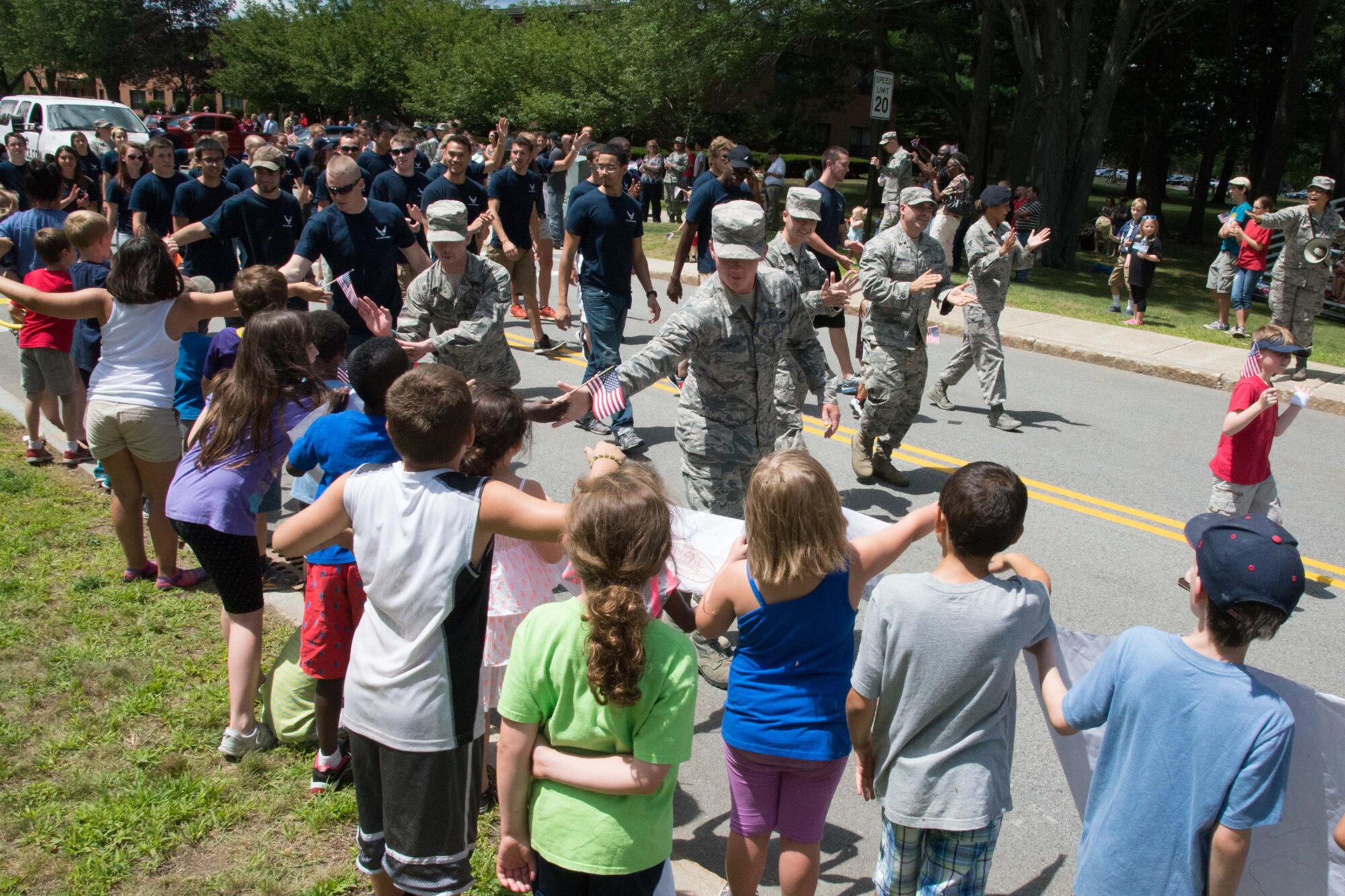 Children from the School Age Program high-five members of the 319th Recruiting Squadron during a Heroes Homecoming parade on base July 23. The base community lined the streets on base to recognize Airmen who have returned home from deployment in the past year during a Heroes Homecoming celebration. (U.S Air Force photo by Mark Herlihy)