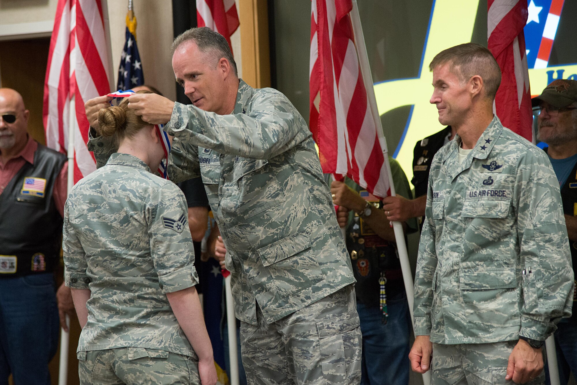 Col. Michael A. Vogel, 66th Air Base Group commander, presents a medallion to Senior Airman Crystal Cardin, 66th Comptroller Squadron, during Heroes Homecoming at the Hanscom Conference Center July 23. Following the ceremony, members of the community lined the streets on base to recognize returning deployers during a parade. The event provided the community an opportunity to welcome home service members who have returned from deployment in the past year. (U.S Air Force photo by Mark Herlihy)