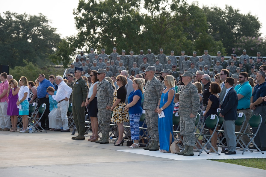 Members of the audience stand as U.S. Air Force Col. Chad Franks, outgoing 23d Wing commander, receives an award during the 23d Wing Change of Command ceremony July 23, 2015, at Moody Air Force Base, Ga. Franks will be moving on to serve as the senior executive officer to the Air Force vice chief of staff. (U.S. Air Force photo by Staff Sgt. Eric Summers/Released)