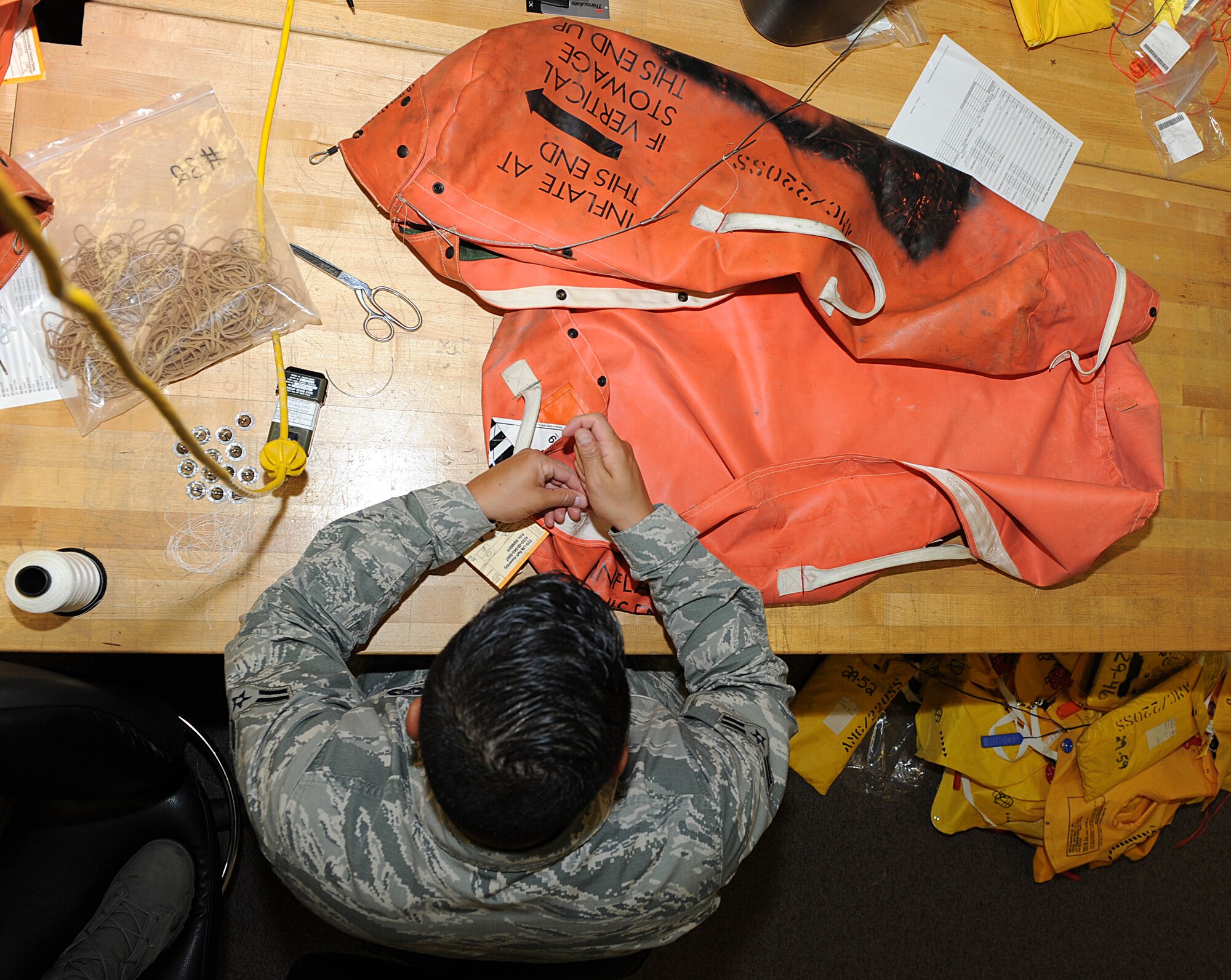 Airman 1st Class Osmel Campos Perez, 22nd Operations Support Squadron aircrew flight equipment technician, sews a life raft’s inner accessory container, July 22, 2015, at McConnell Air Force Base, Kan. The life raft configuration used is specific to KC-135 Stratotankers as directed by Air Mobility Command. (U.S. Air Force photo by Senior Airman David Bernal Del Agua)