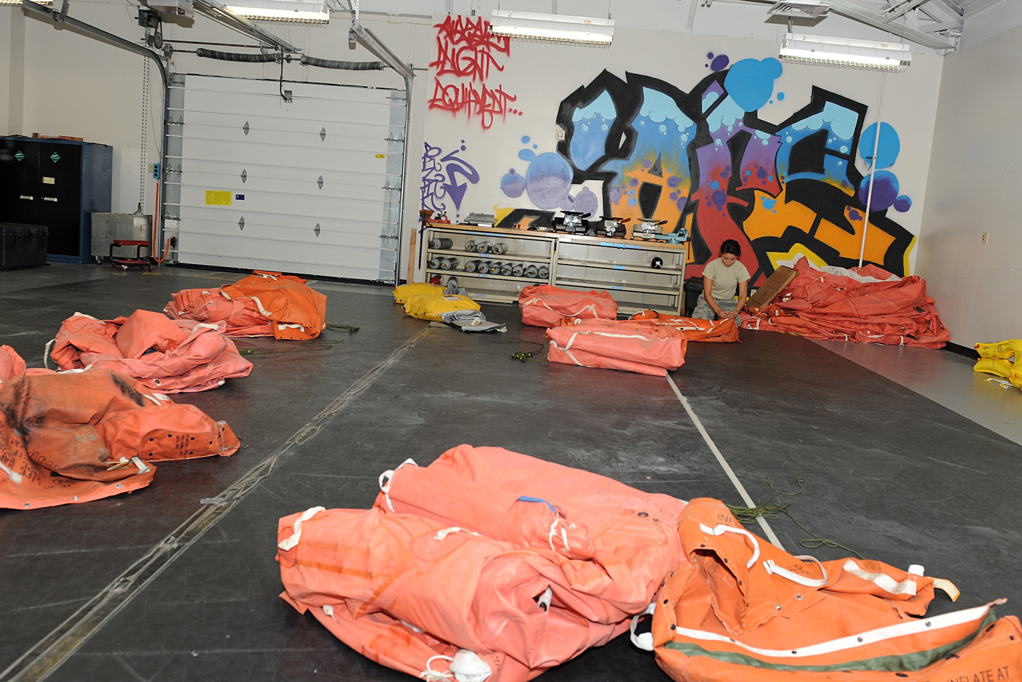 Airman 1st Class Michelle Martos, 22nd Operations Support Squadron aircrew flight equipment technician, closes a life raft’s inner accessory container, July 22, 2015, at McConnell Air Force Base, Kan. The Airmen inspect 67 sets of life rafts yearly to ensure they are safe for aircrew to deploy during an emergency. (U.S. Air Force photo by Senior Airman David Bernal Del Agua)