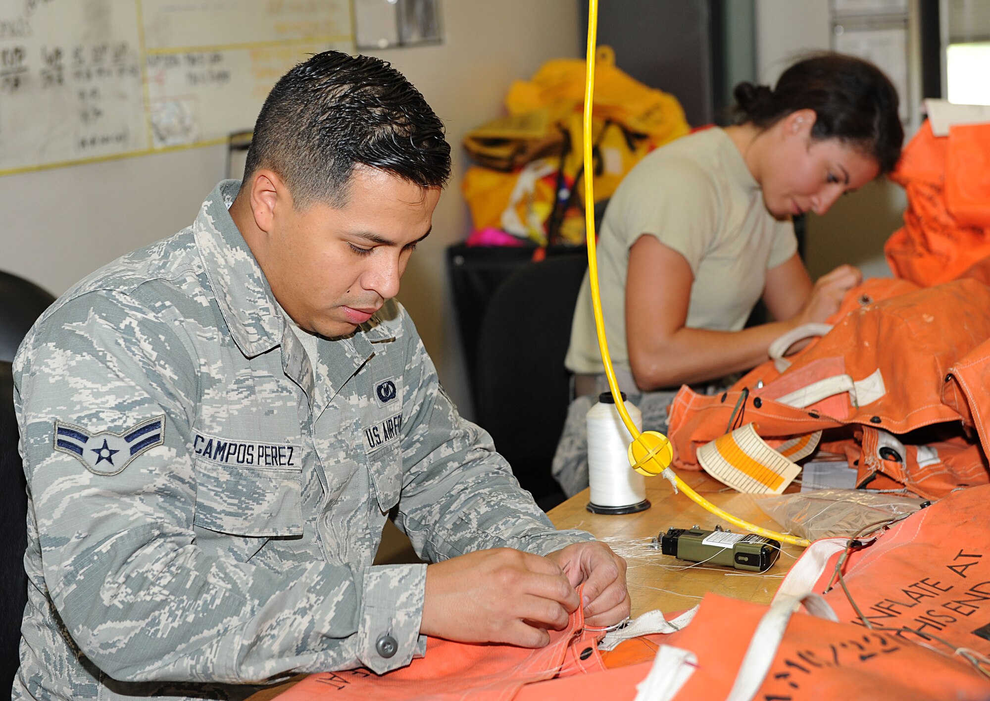Airmen 1st Class Osmel Campos Perez and Michelle Martos, 22nd Operations Support Squadron aircrew flight equipment technicians, prepare a survival kit, July 22, 2015, at McConnell Air Force Base, Kan. The Airmen spend one week completing a set of F2B 20-man Life Raft equipment. (U.S. Air Force photo by Senior Airman David Bernal Del Agua)