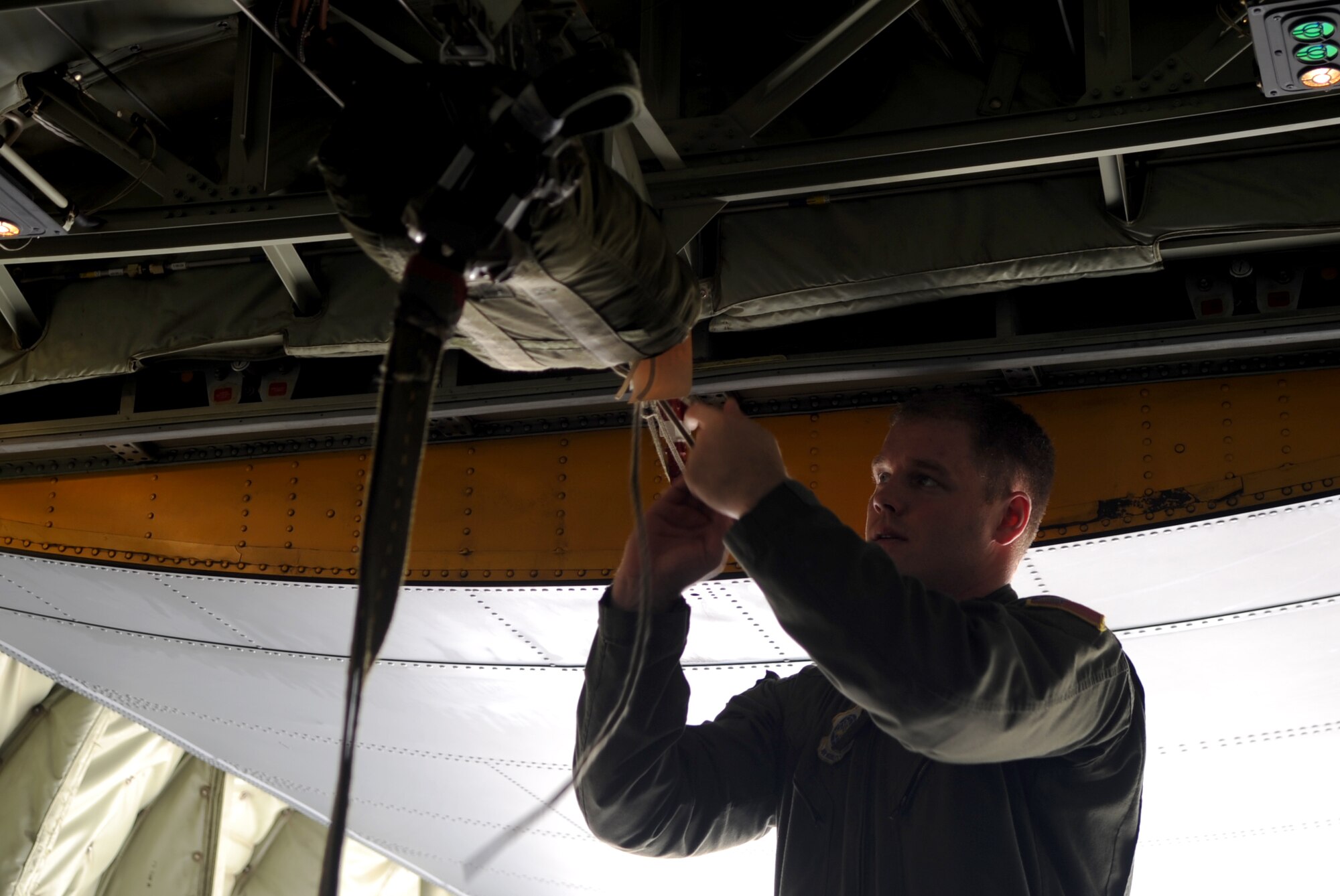U.S. Air Force Staff Sgt. Daniel Simonsen, 39th Airlift Squadron loadmaster secures a parachute to the C-130J Super Hercules’ cargo rack, June 30, 2015, at Dyess Air Force Base, Texas. The cargo rack releases the parachute which pulls the load out of the aircraft. (U.S. Air Force photo by Airman 1st Class Austin Mayfield/Released)