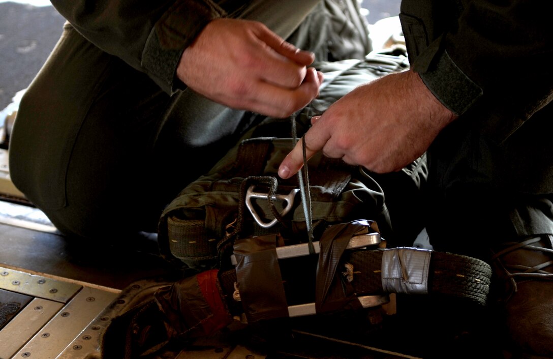 U.S. Air Force Staff Sgt. Daniel Simonsen, 39th Airlift Squadron loadmaster, secures a parachute to a heavy equipment platform, June 30, 2015, at Dyess Air Force Base, Texas. When the cargo is deployed the parachute drops into the aircraft’s slip stream, breaks open and drags the load out of the aircraft. (U.S. Air Force photo by Airman 1st Class Austin Mayfield/Released)
