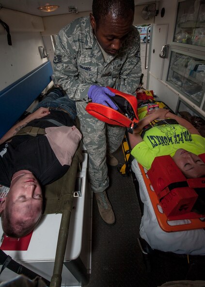 Staff Sgt. Jeremy Osborn (left), 5th Munitions Squadron conventional munitions crew chief and Senior Airman Sabrina Sacher (right), 5th MUNS unit deployment manager, receive simulated treatment from Staff Sgt. Tyrone Sharpe, 5th Medical Operations Squadron ambulance services member, during an exercise at Minot Air Force Base, N.D., July 22, 2015. The exercise tested the skills of emergency response personnel and a variety of base agencies: firefighters, emergency medical technicians and 54th Helicopter Squadron crew members. (U.S. Air Force photo/Senior Airman Stephanie Morris)