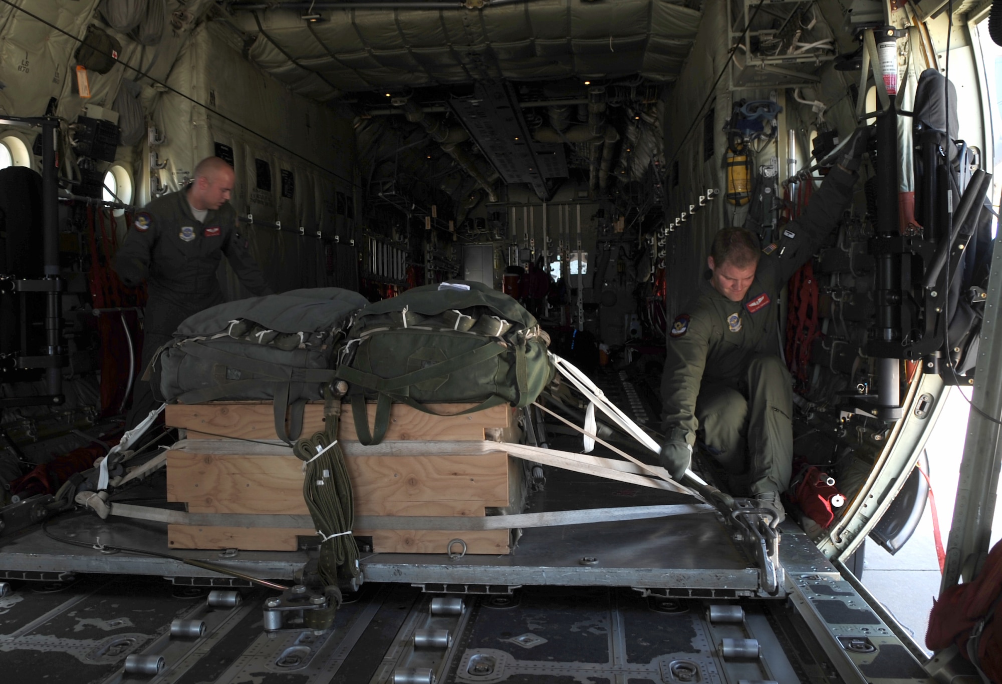 U.S. Air Force Staff Sgt. Justin King, left, and Staff Sgt. Daniel Simonsen, right, both loadmasters assigned to the 39th Airlift Squadron, secure straps to hold a heavy equipment platform in a C-130J Super Hercules, June 30, 2015, at Dyess Air Force Base, Texas. Loadmasters are trained to load and perform airdrops such as combat support, low-cost-low-altitude, combat rubber raiding craft and personnel. (U.S. Air Force photo by Airman 1st Class Austin Mayfield/Released)