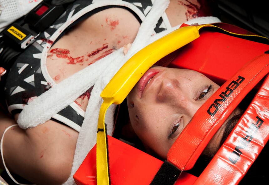 Staff Sgt. Symphony Leyk, 5th Security Forces Squadron alarm monitor, lies in an ambulance during an exercise at Minot Air Force Base, N.D., July 22, 2015. Leyk, and one other simulated victim, was transported to Trinity Hospital to simulate realistic steps that would be taken during a mass casualty response. (U.S. Air Force photo/Senior Airman Stephanie Morris)