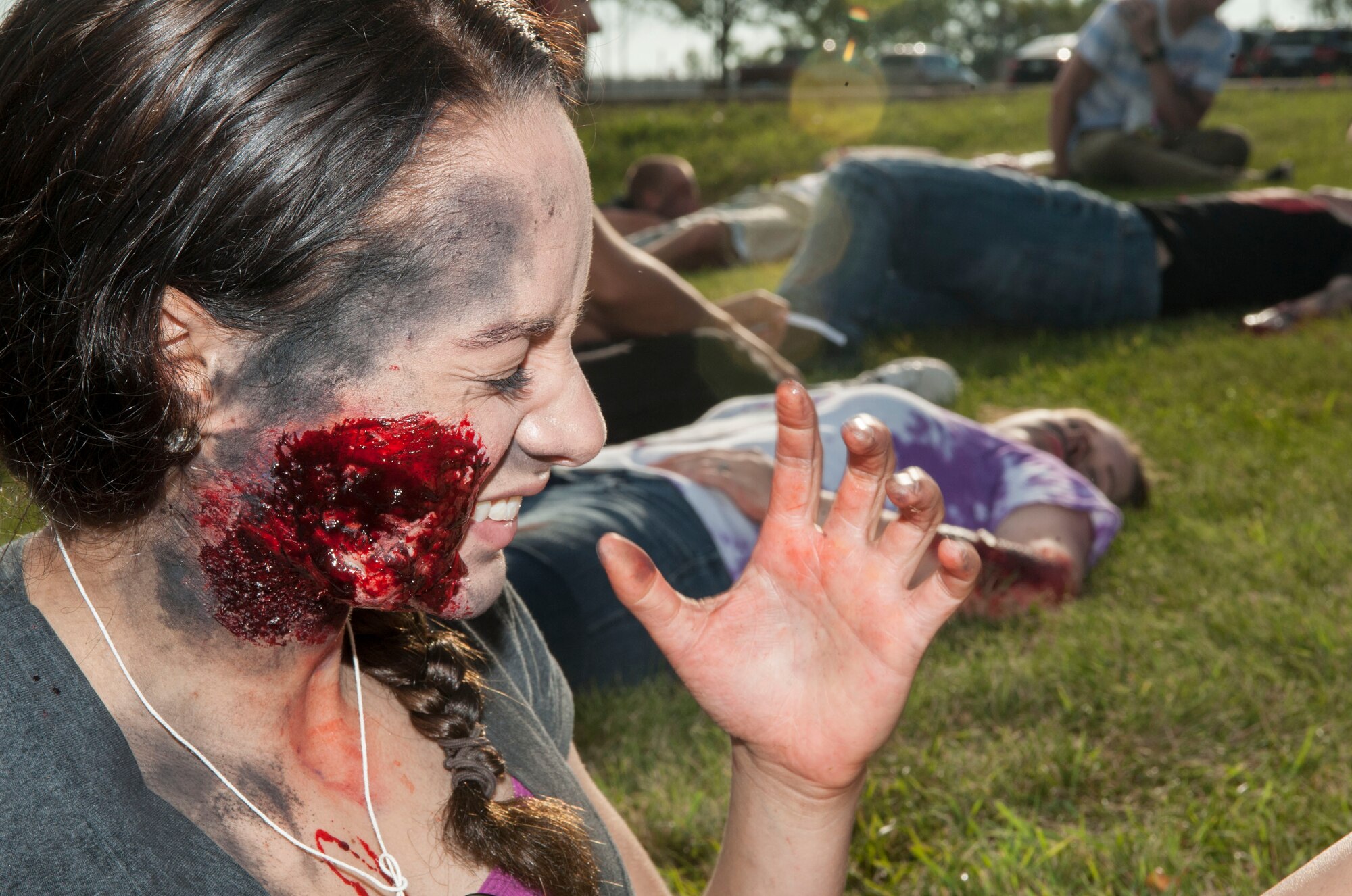 Airman 1st Class Aleah Meade, 5th Munitions Squadron storage crew member, grimaces from a mock burn wound during an exercise at Minot Air Force Base, N.D., July 22, 2015. Meade was one of approximately 40 volunteers who portrayed trauma victims during the exercise. (U.S. Air Force photo/Senior Airman Stephanie Morris)